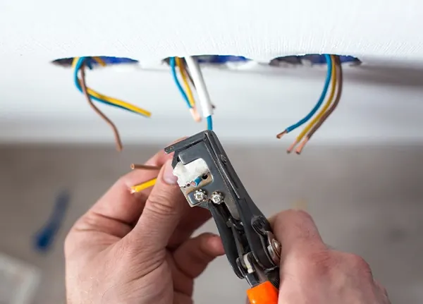Electrician stripping wires during a whole-home rewiring project in Leland, NC